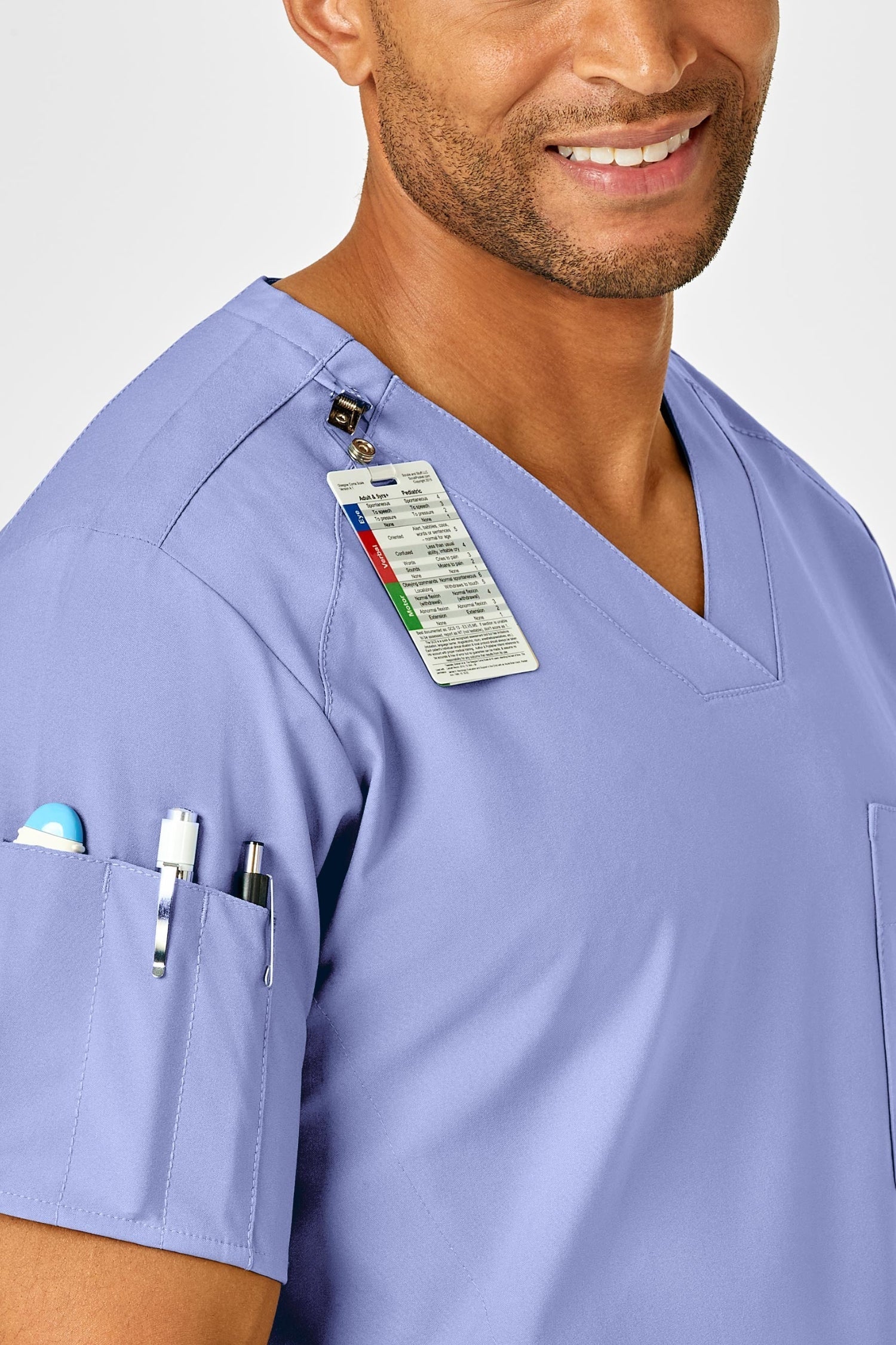 Professionnel de santé en tenue médicale complète bleu ciel avec badge et stylos