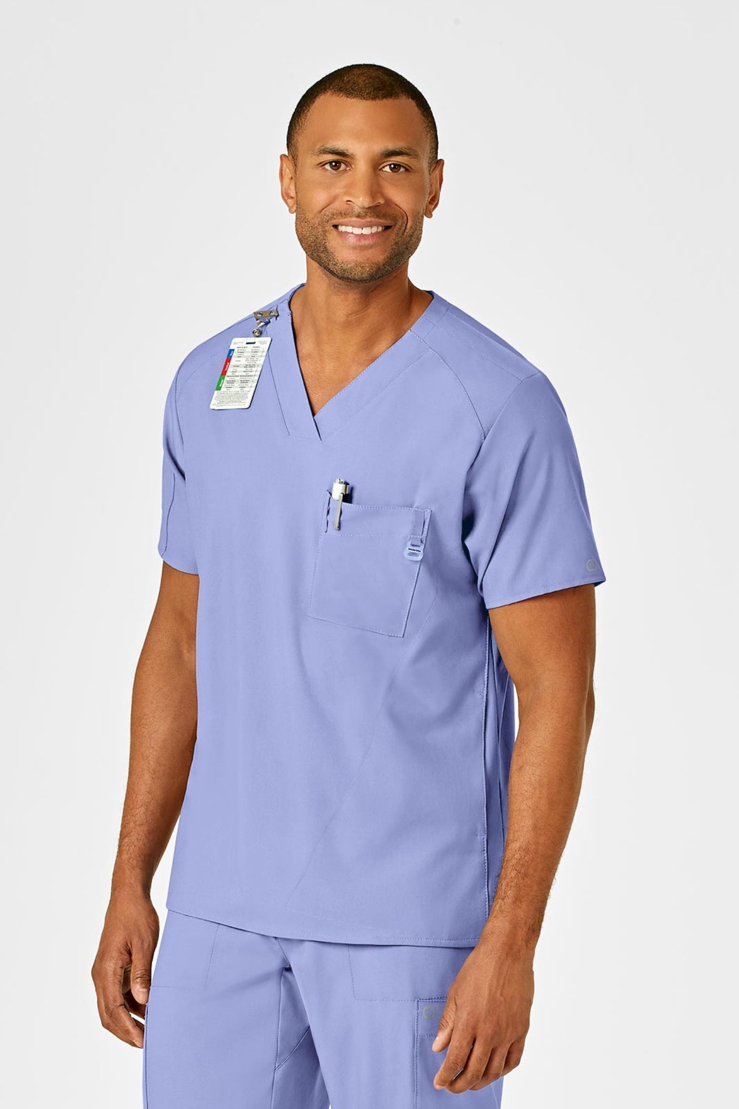 Travailleur de santé en tenue médicale complète bleu ciel avec badge d’identification